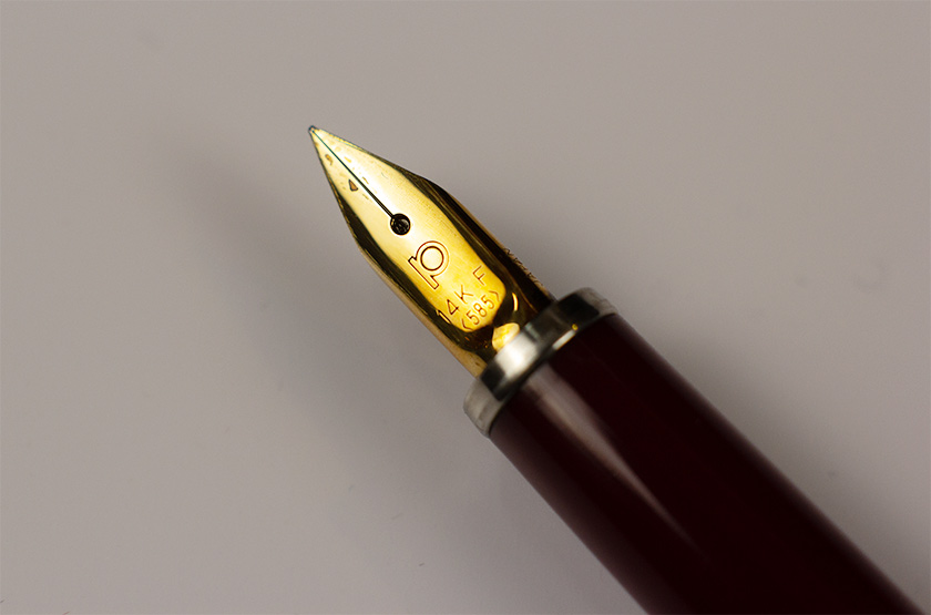 Close-up of the Platinum PTL-5000a 14k gold nib stamped with F 585, on burgundy red pen body